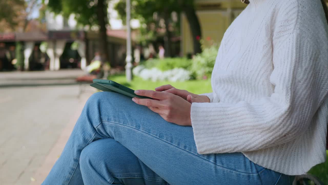 户外木凳上使用写字板的妇女，特写视频下载