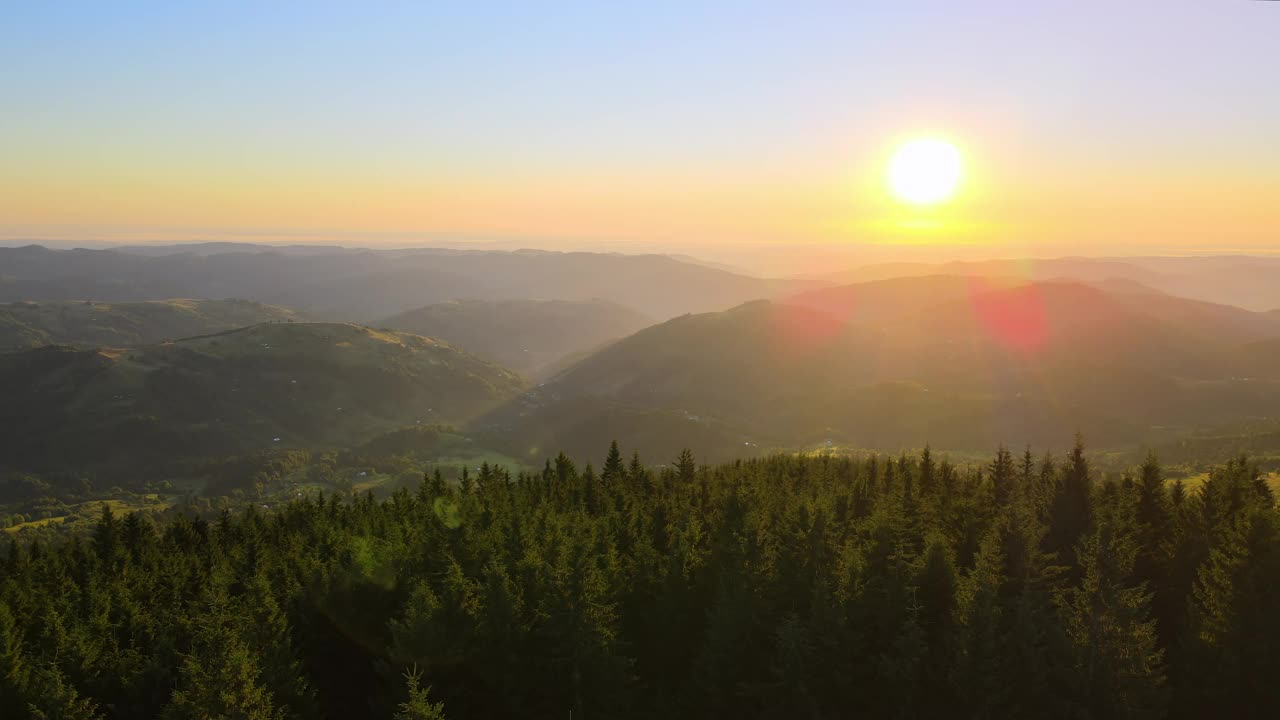 令人惊叹的山地景观。黑暗的云杉树林被黄色的夕阳照亮。在野生国家公园高地上明亮多彩的日落视频素材