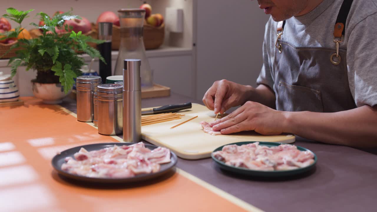 一位中年男子正在厨房准备食物视频素材