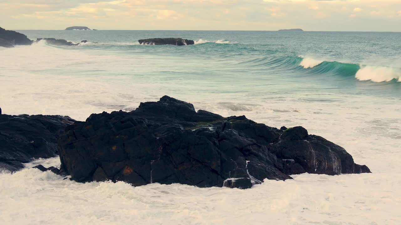 海洋海浪撞击大岩石，岩石海岬，海岸特征，考夫斯港，澳大利亚。视频素材