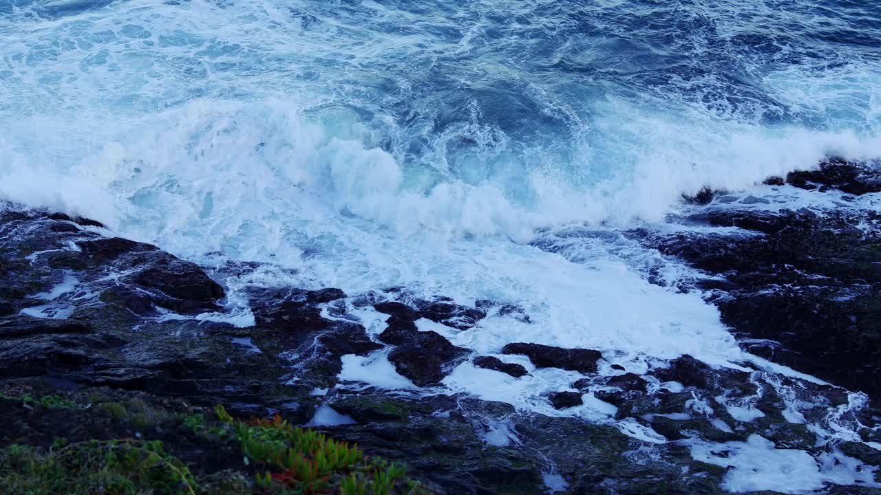 海浪冲击岩石岬角，大自然的力量背景。4 k的视频。视频素材