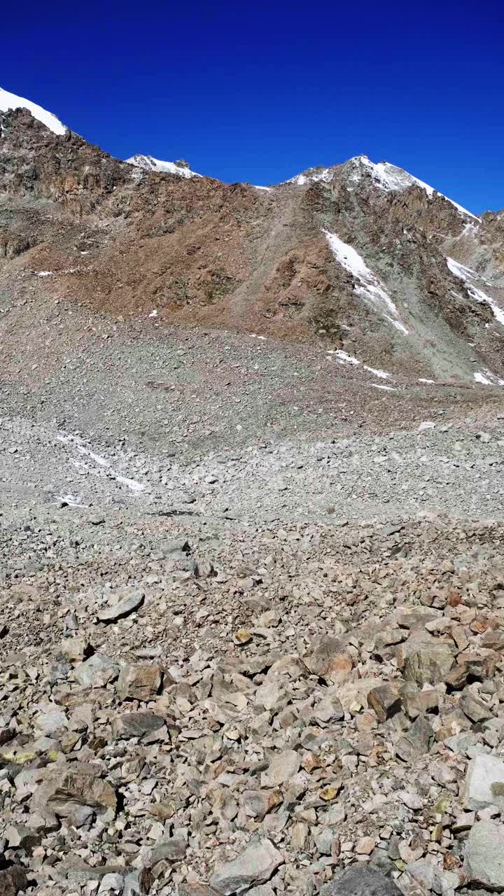 山峰上的雪帽在夏日的阳光下闪闪发光视频素材