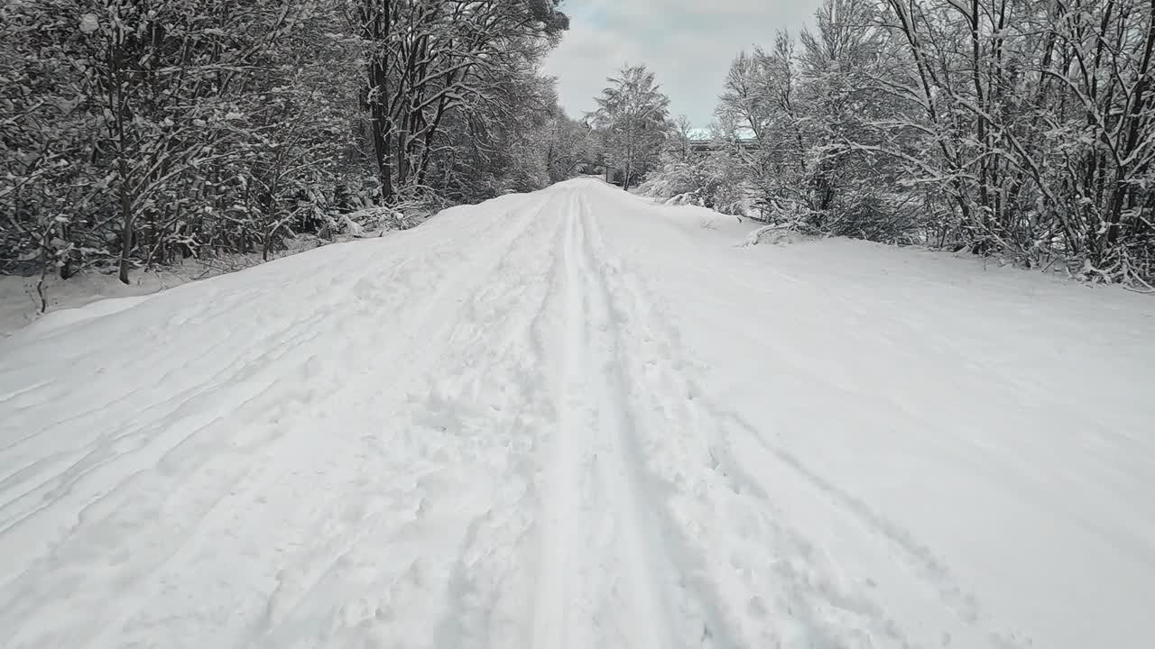 越野滑雪后，雪覆盖两侧的针叶树，河流附近的动作镜头的角度视频下载