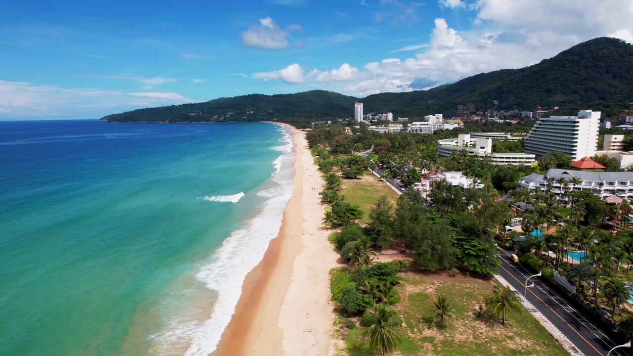 鸟瞰海岸海滩和山脉，现代建筑，非常适合放松和探索。泰国普吉岛卡隆海滩视频素材