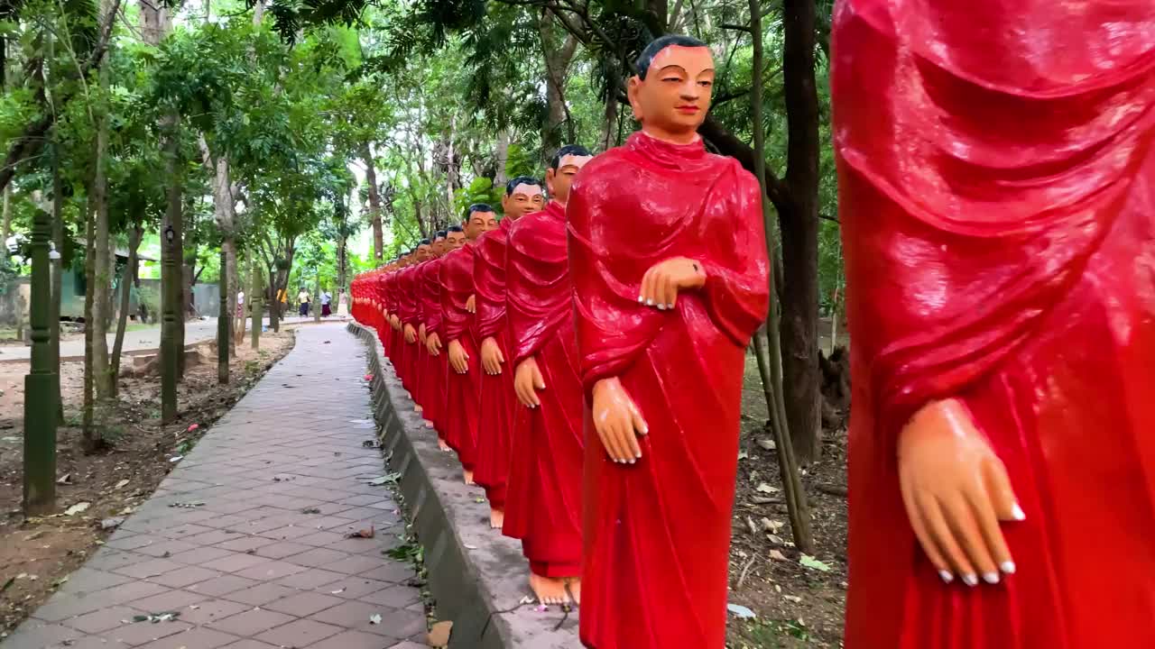 弟子跟随佛陀的雕像，描绘了一个神圣而宁静的场景。视频下载