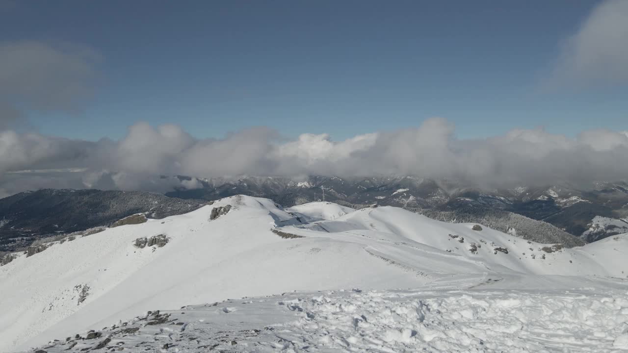 一个高山度假胜地的鸟瞰图被白雪覆盖的树木和山脉包围，提供一个完美的冬季度假视频素材