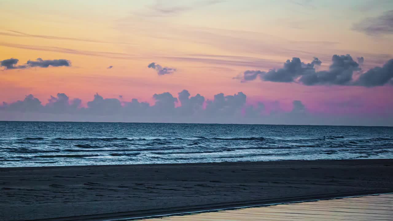 五彩缤纷的日落在一个宁静的海滩与温柔的海浪和宁静的天空，时间流逝视频素材