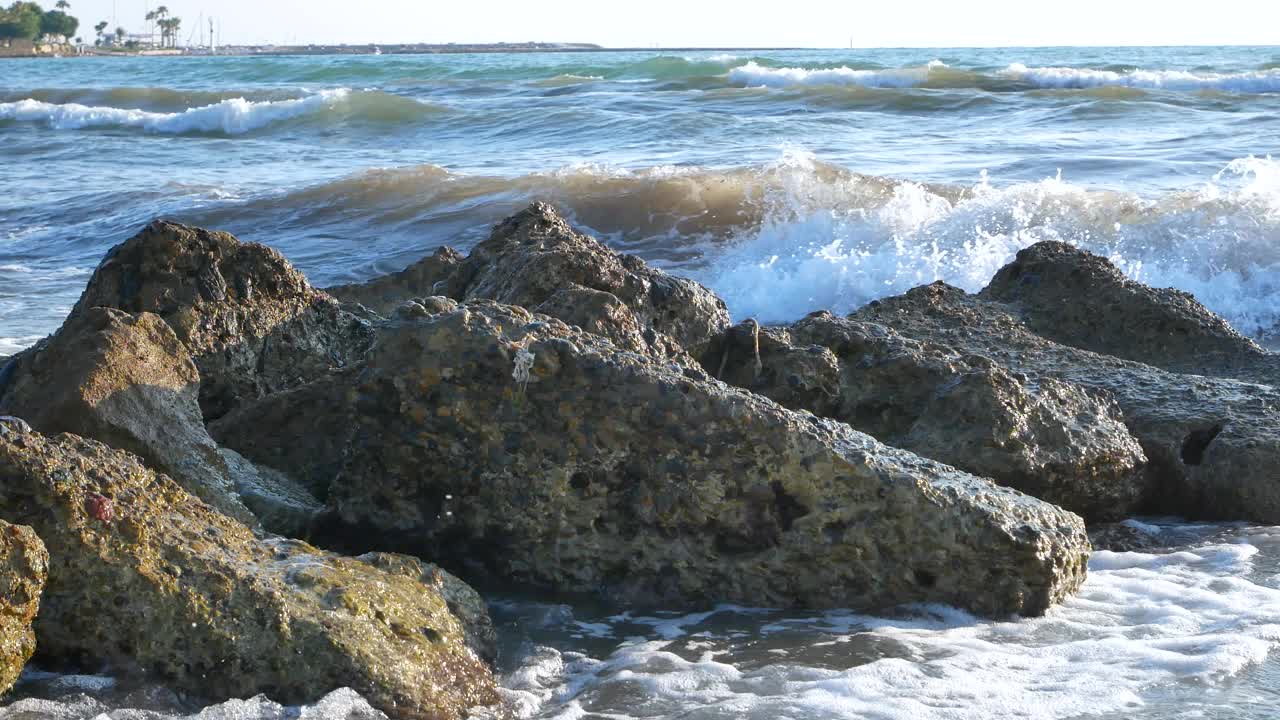 海浪冲击着荒凉海岸上的一块大石头。视频下载