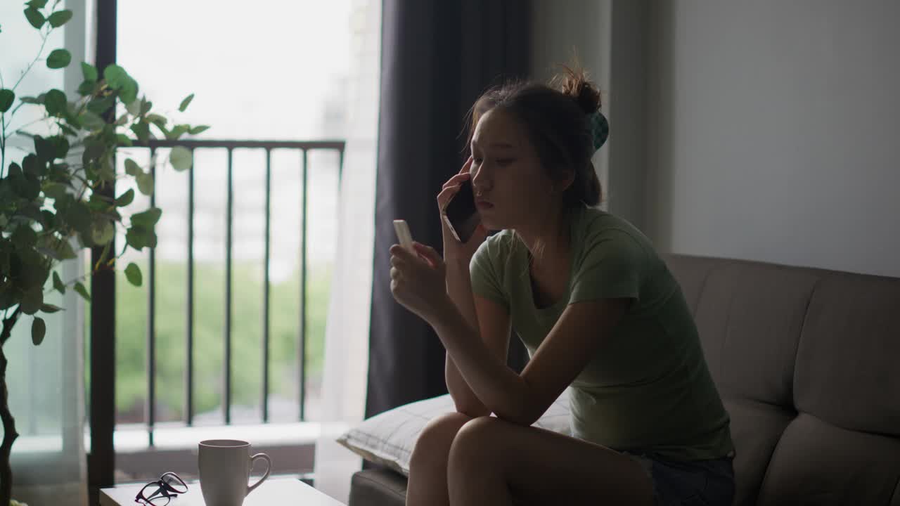 年轻的亚洲女性在看了验孕棒后的表情带着沮丧和意外视频素材