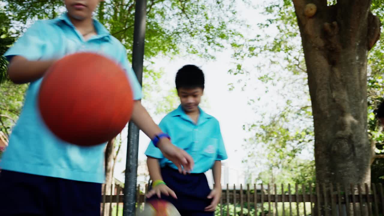 孩子们在学校操场上练习篮球视频素材