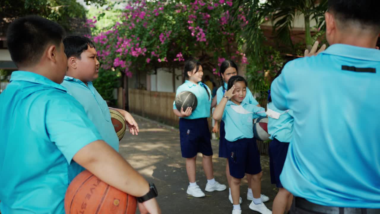 学校体育老师在训练中指导孩子们打篮球视频素材