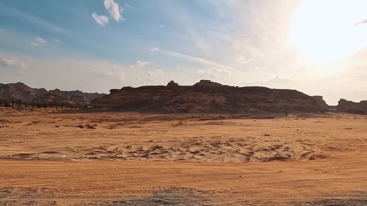 驾车行驶在阿尔乌拉的主干道上(从汽车上看)，明亮的阳光照在远处有岩石形成的沙地上视频下载