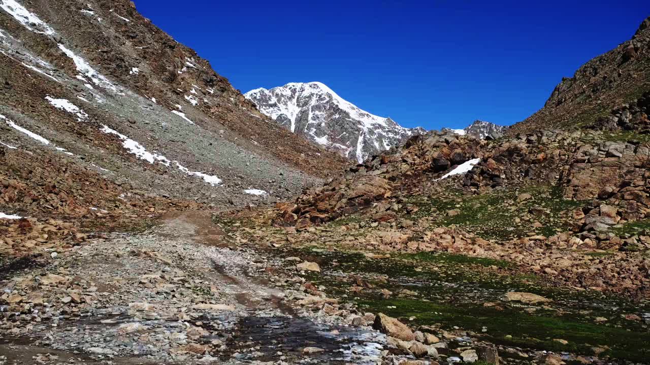 夏季山口顶部冰冻水坑上的轮胎痕迹视频素材