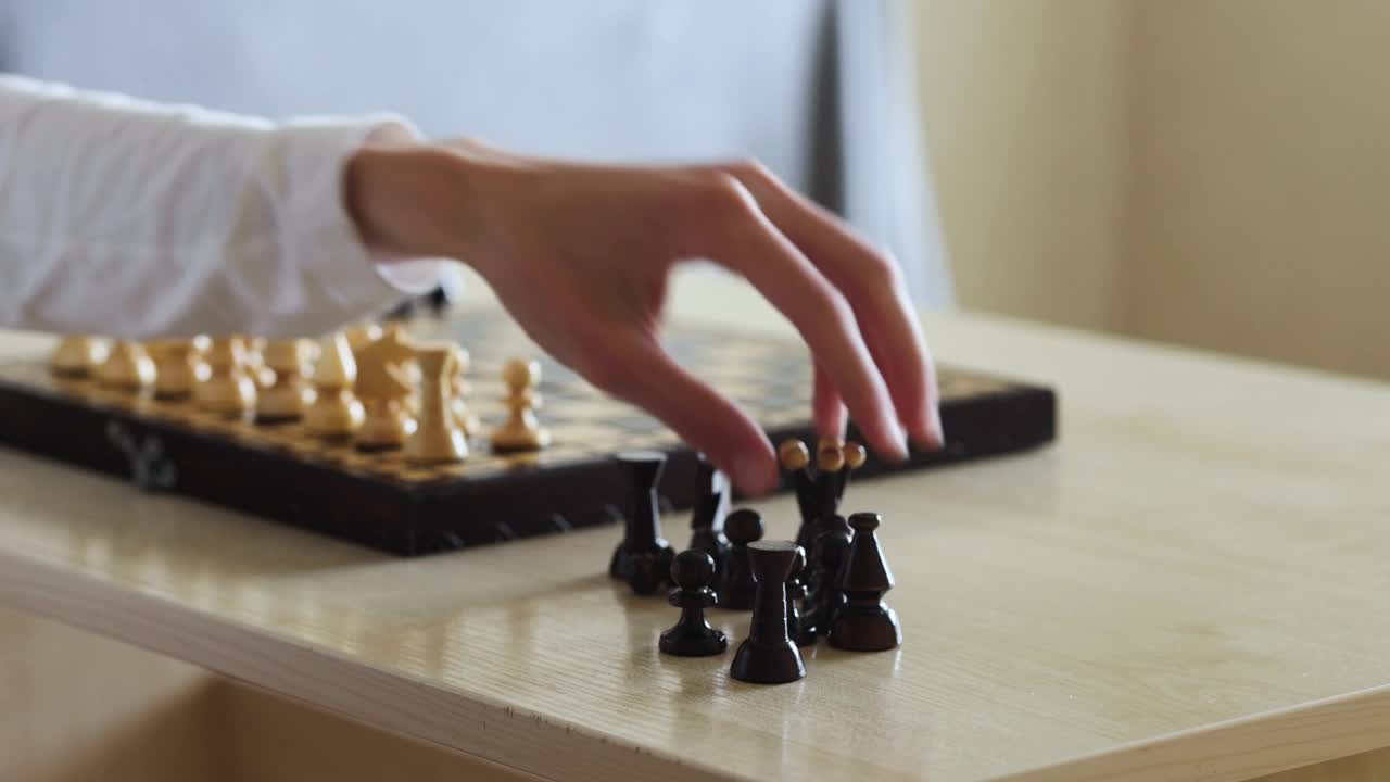 一个人下棋，在木制棋盘上移动一个黑色的棋子视频素材