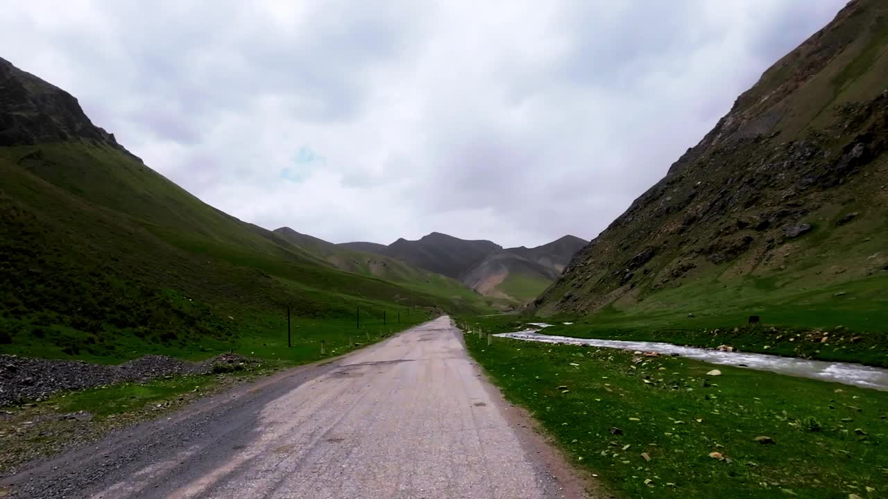 沿着古老的柏油路，沿着风景秀丽的峡谷，在壮观的天空下旅行视频素材