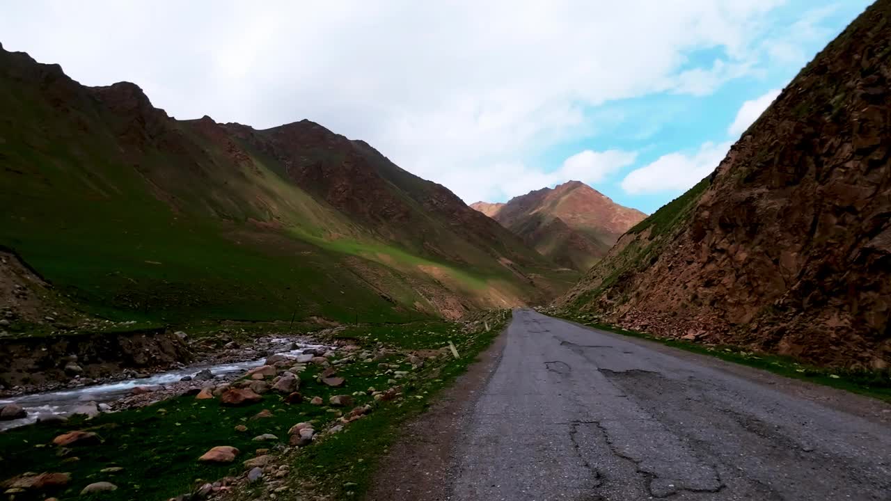 在美丽的天空下，沿着风景如画的峡谷行驶在古老的柏油路上视频素材