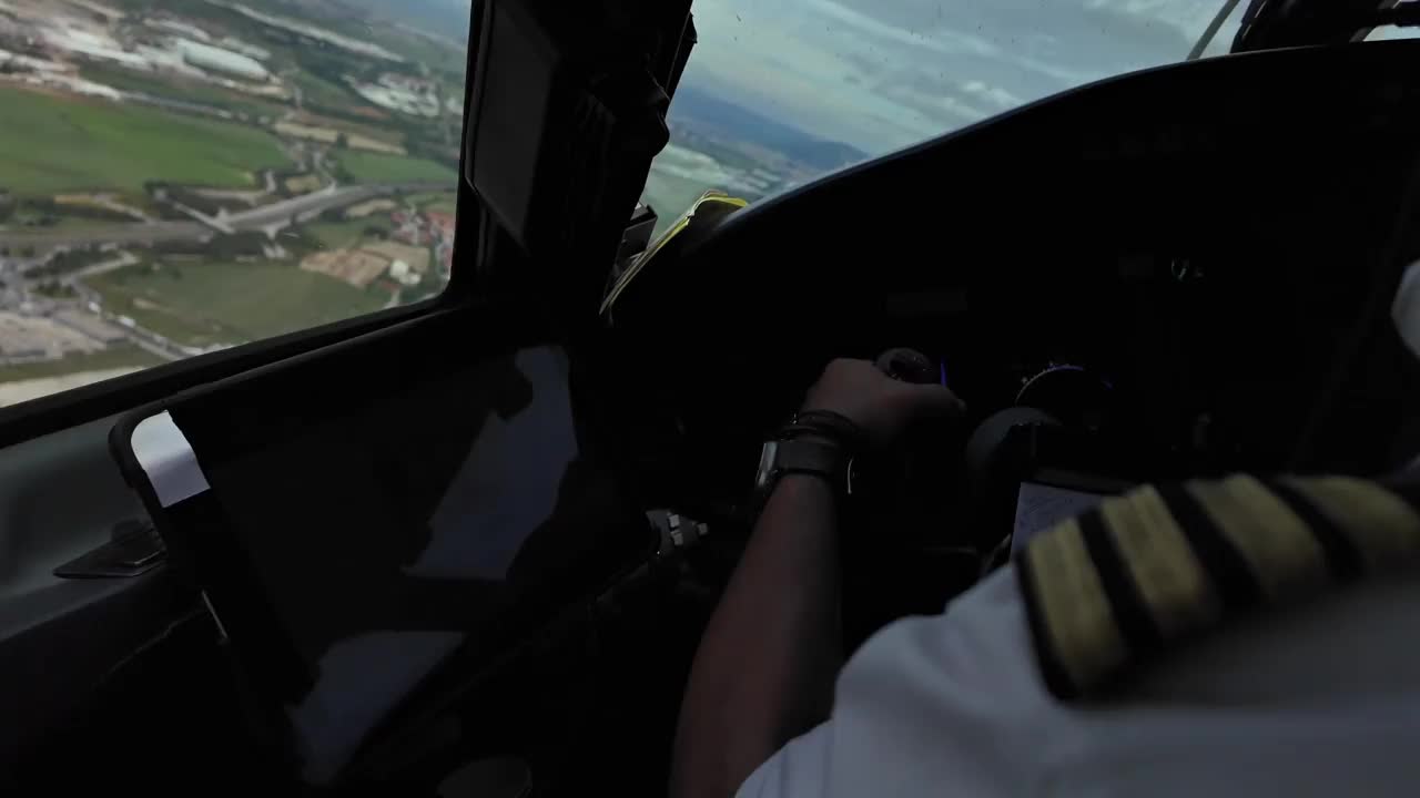 沉浸式飞机驾驶舱场景。一名白人飞行员驾驶一架喷气式飞机低空接近跑道。队长一边。4 k视频素材