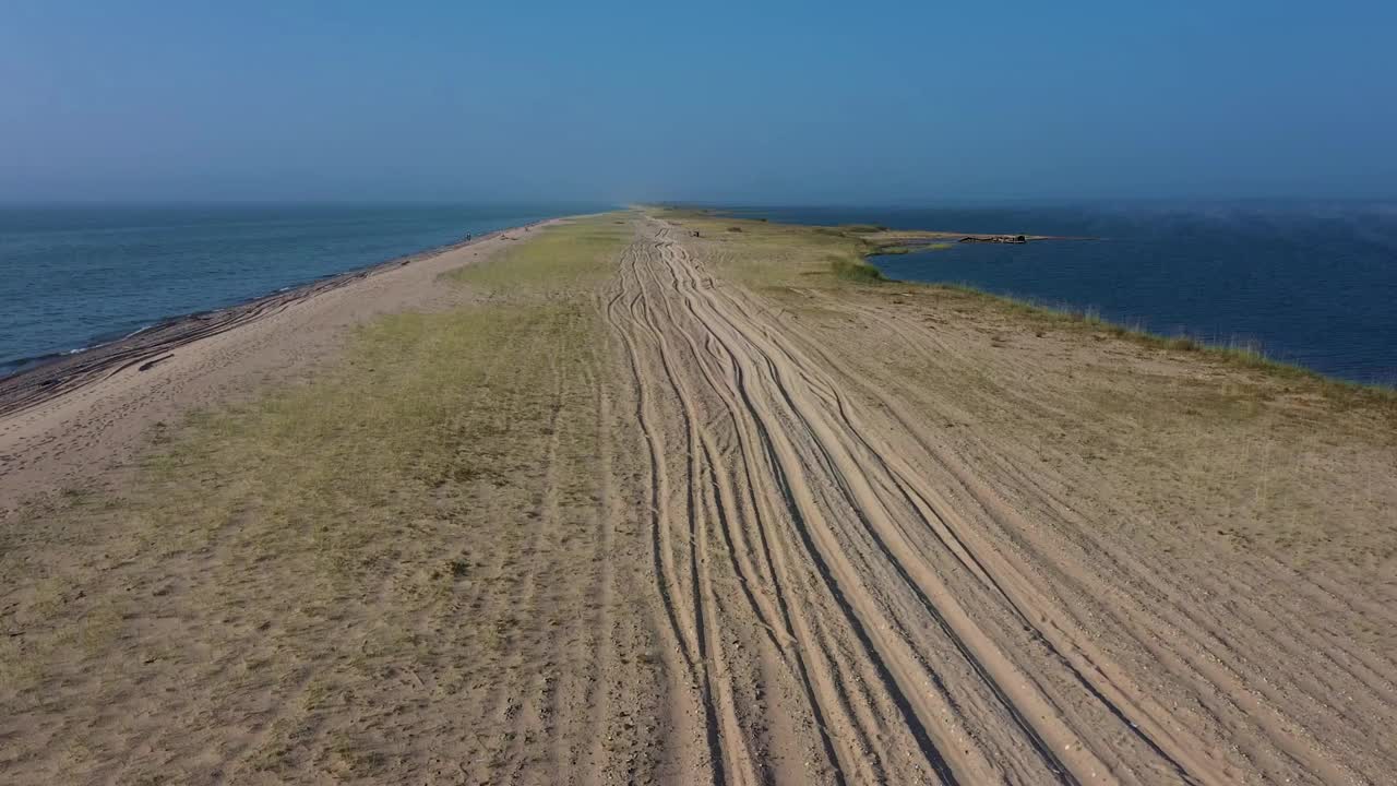 探索延伸到海洋的遥远沙洲，穿越宁静的沿海通道视频素材