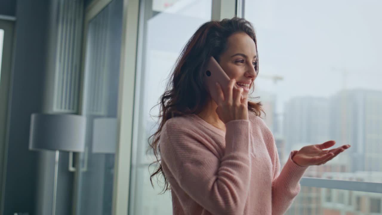 有魅力的女人说话的细胞现代玻璃公寓特写。女孩享受电话视频素材