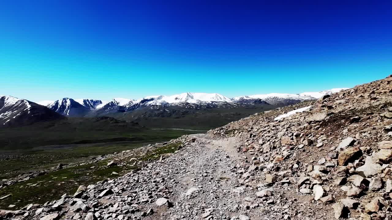 通往白雪皑皑的山脊的岩石小径视频素材