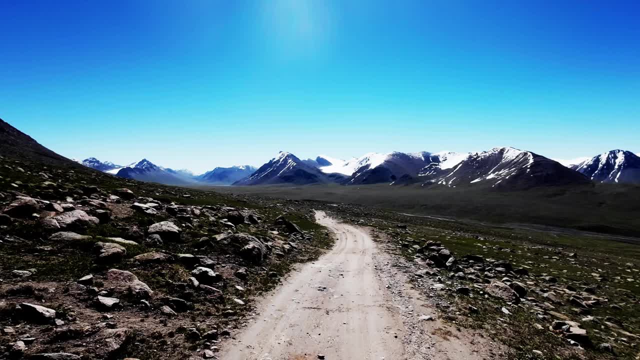 沿着肮脏的小路走到白雪皑皑的山脊视频素材