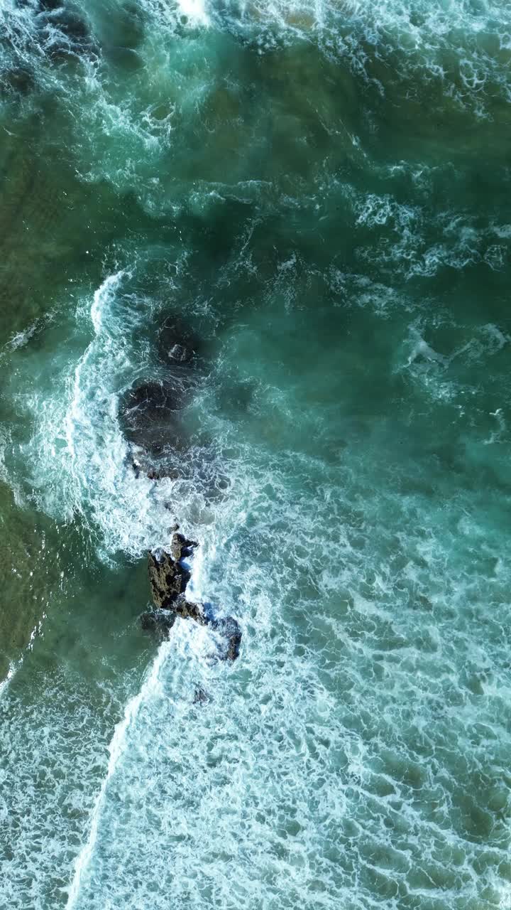 从空中俯瞰，海浪拍打着岩石视频下载