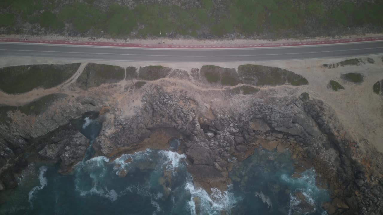 航拍无人机在葡萄牙金乔崎岖的海岸线和道路上自上而下的超俯视频下载