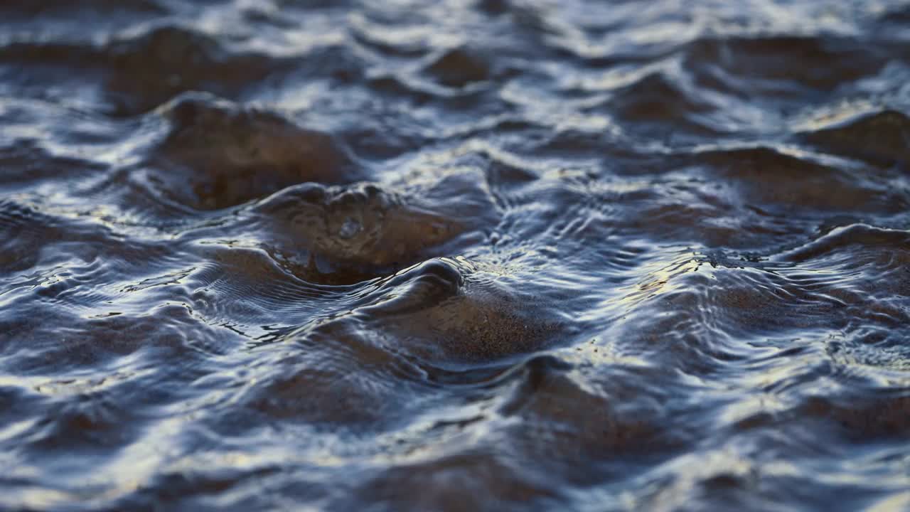 日落时，在清澈的海水中，浅浅的沙洲上形成了微型波浪涟漪。视频素材