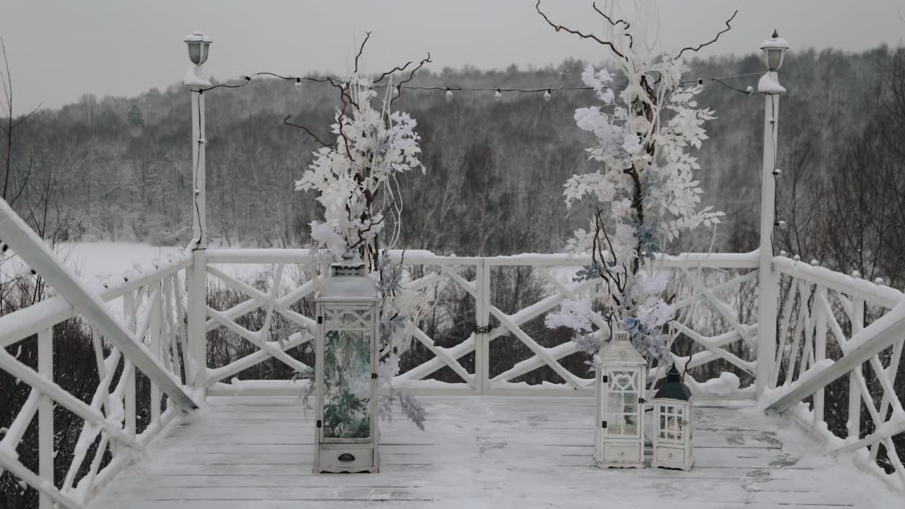 冬天，婚礼拱门矗立在森林上方小山上的木制平台上。总平面图拍摄视频素材