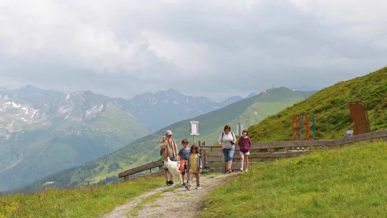 阳光明媚的一天，一家人在奥地利阿尔卑斯山徒步旅行视频素材