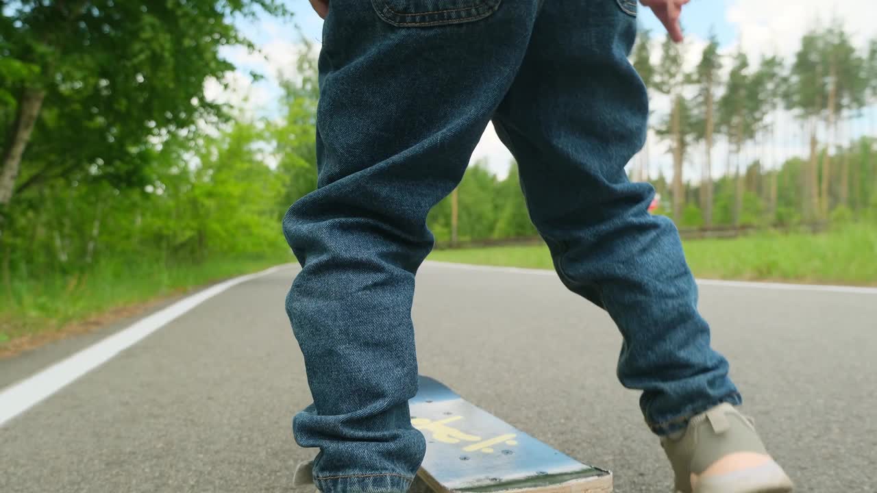 小女孩在柏油路上学习滑板。快乐的女孩在夏天骑滑冰在街上视频素材