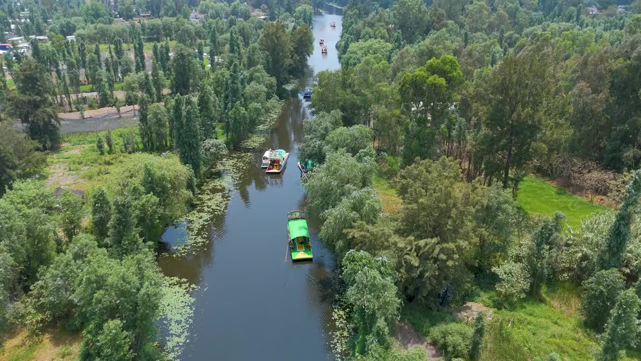 墨西哥城霍奇米尔科的航拍视频:在这里，你可以在当地特有的植被中，在宁静的运河上观察到一些色彩缤纷的trajinera。宁静美丽的墨西哥传统旅游胜地。视频素材