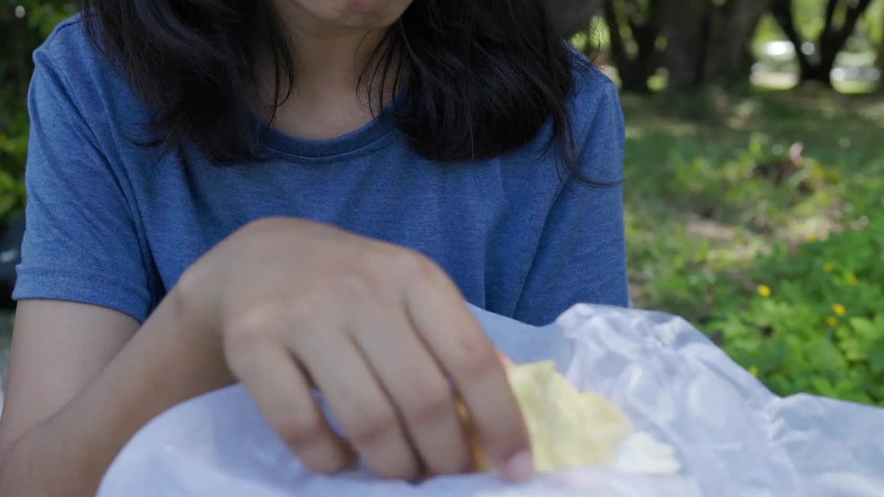 亚洲妇女在泰国水果市场吃新鲜的榴莲皮。视频下载