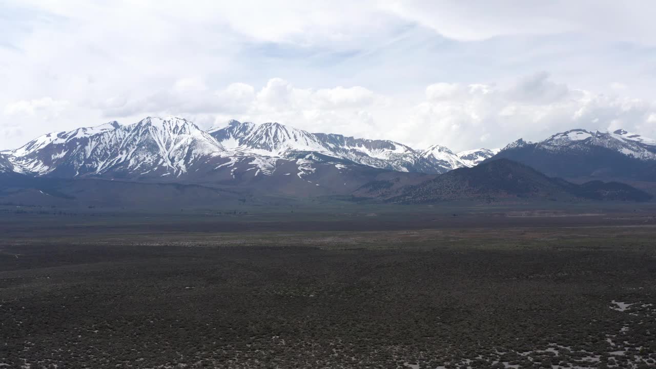 从加州395号高速公路上看白雪皑皑的火山口山和风成山丘视频素材