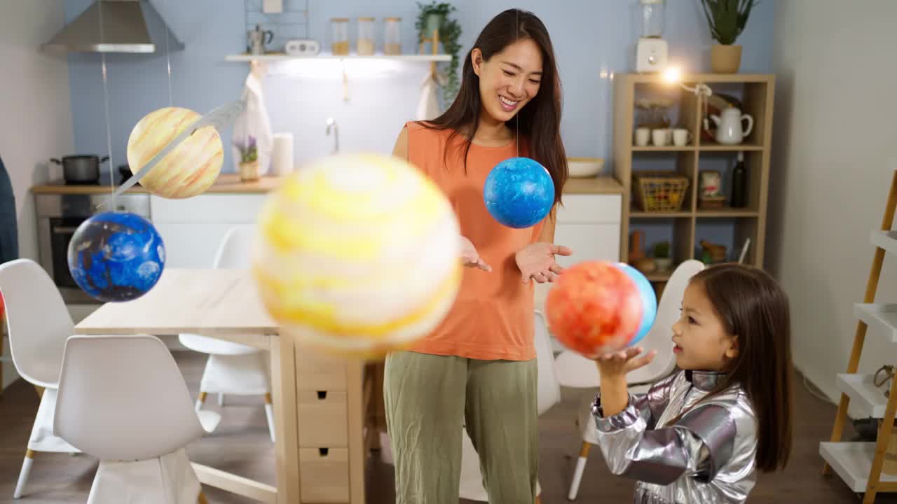 穿着太空服的女孩和她妈妈一起探索和学习行星视频素材