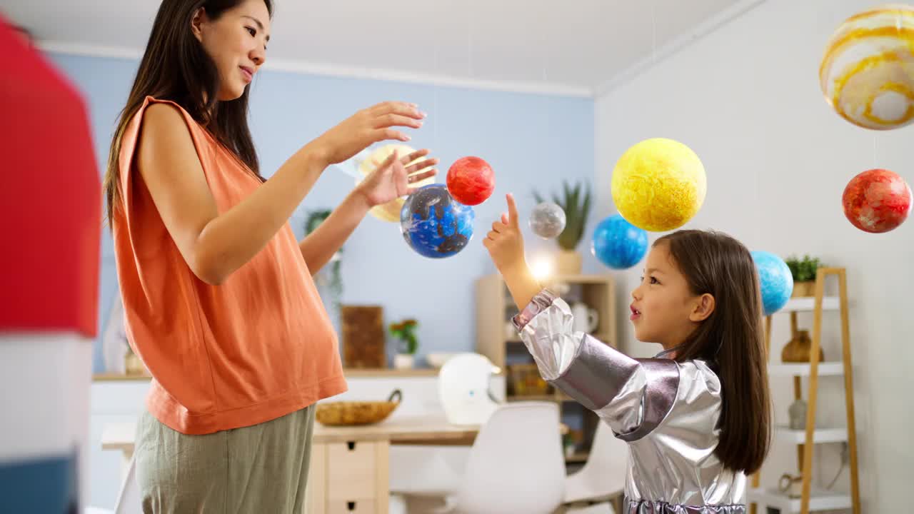 穿着太空服的女孩和她妈妈一起探索和学习行星视频素材