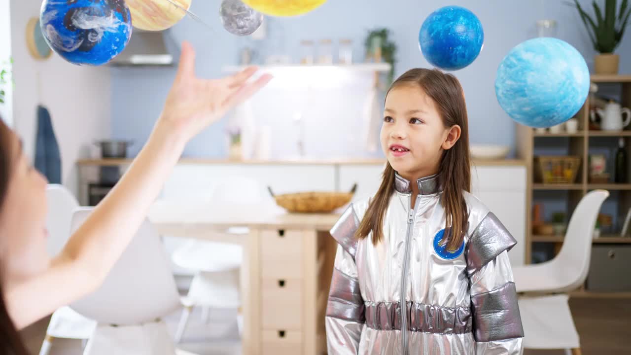 穿着太空服的女孩和她妈妈一起探索和学习行星视频素材