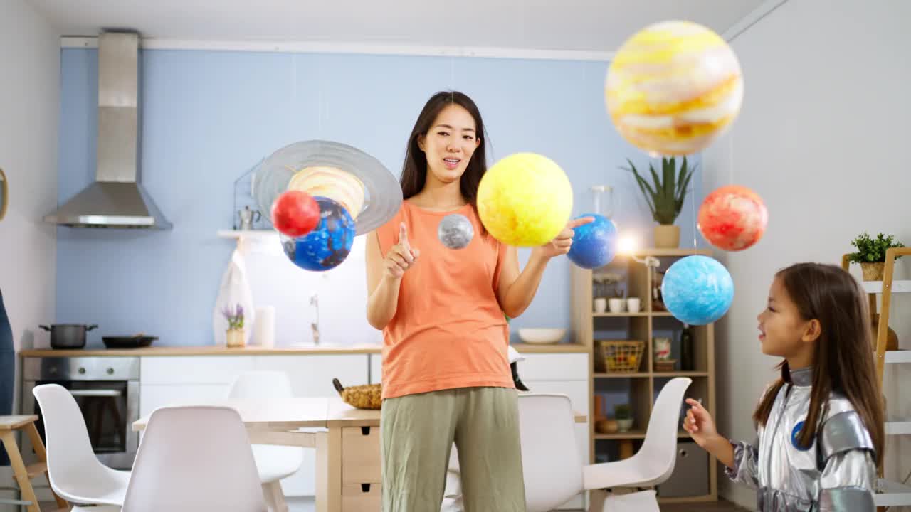 穿着太空服的女孩和她妈妈一起探索和学习行星视频素材