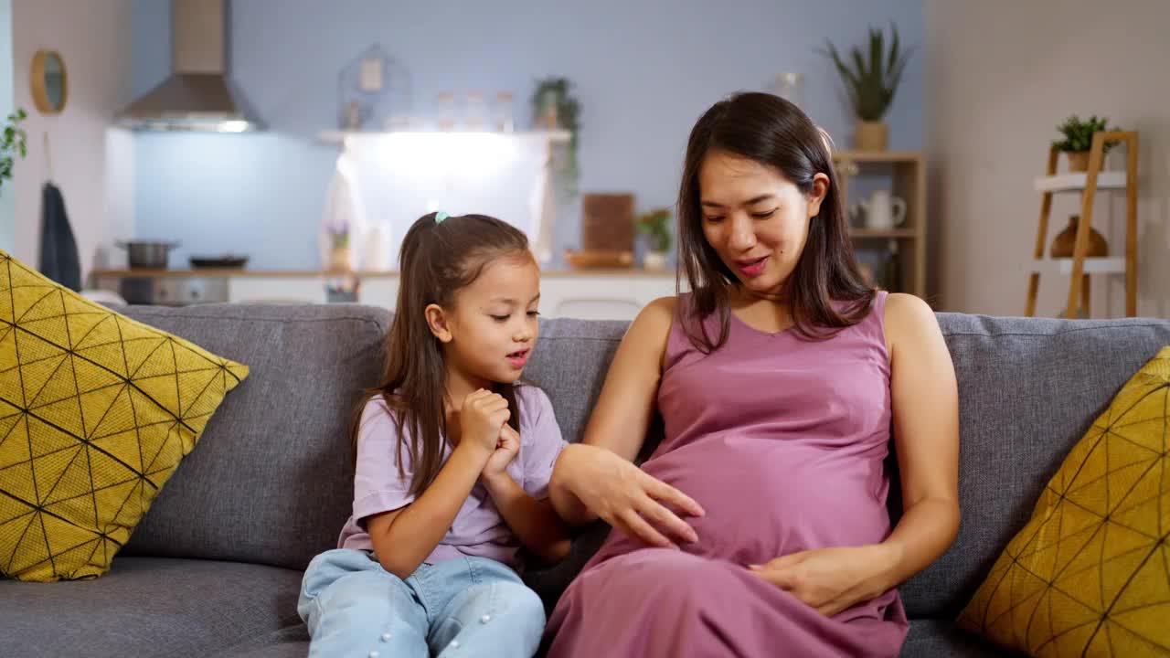 怀孕的母亲和她的女儿在家里共度时光视频素材