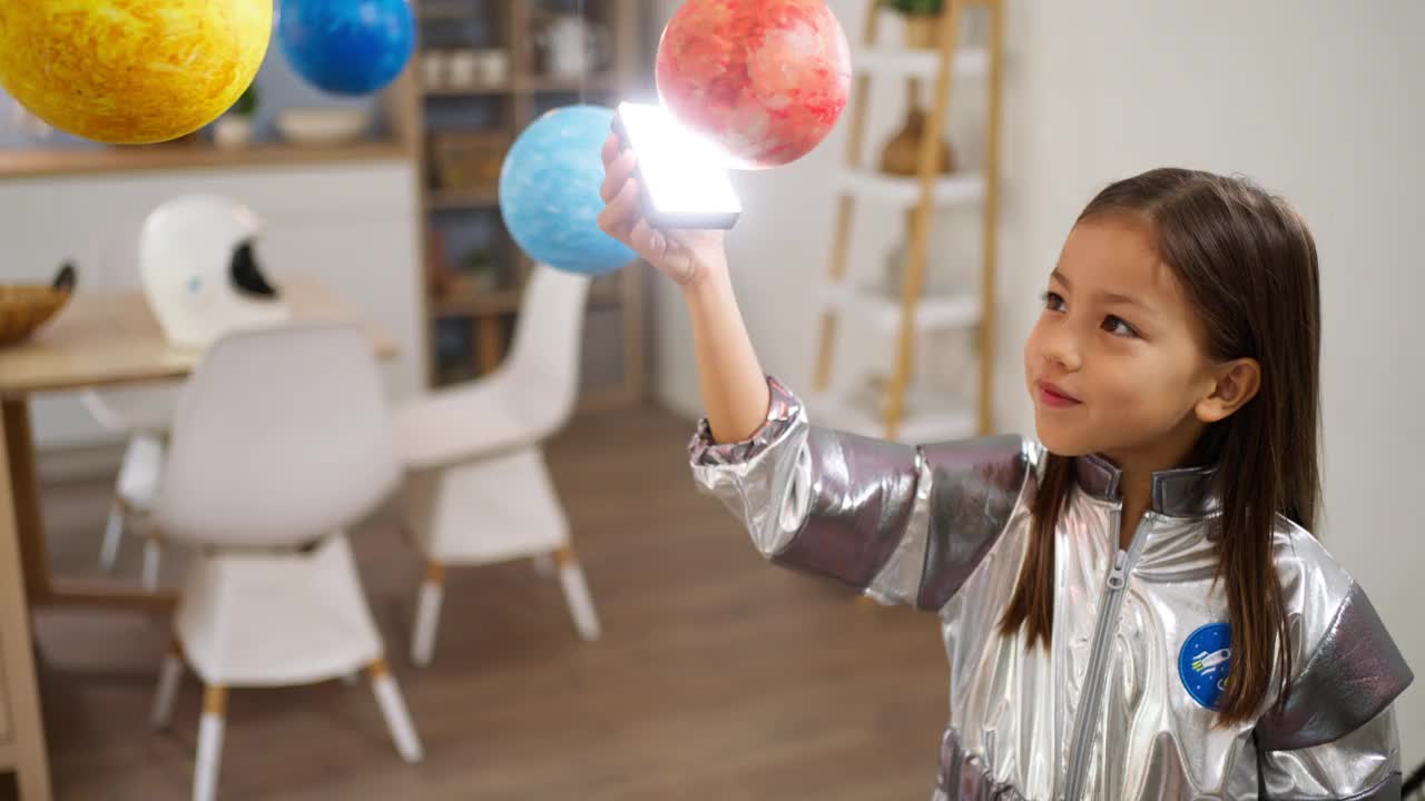 穿着太空服的女孩和她妈妈一起探索和学习行星视频下载