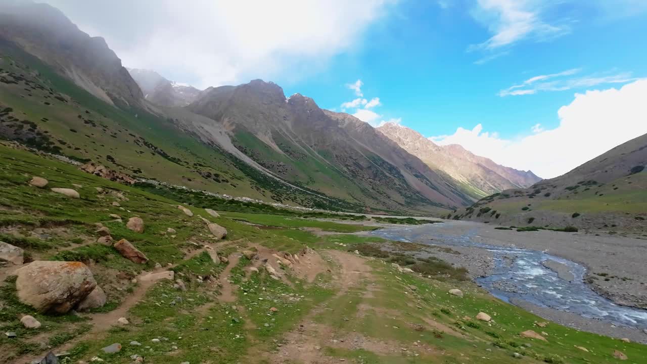 在阴云密布的夏日峡谷中，沿着风景如画的山河岸行进视频素材