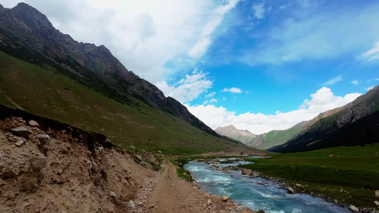 在阴云密布的夏日峡谷中，沿着风景如画的山河岸行进视频素材