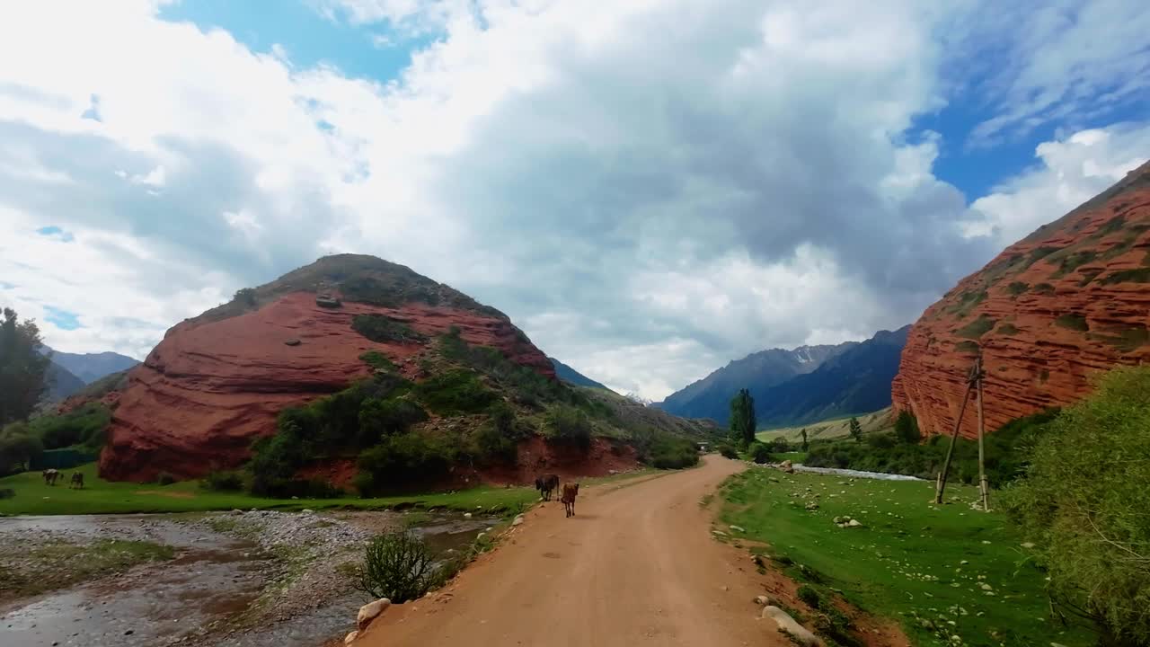 在云层下的夏日峡谷的红色岩石形成的河岸上移动视频素材