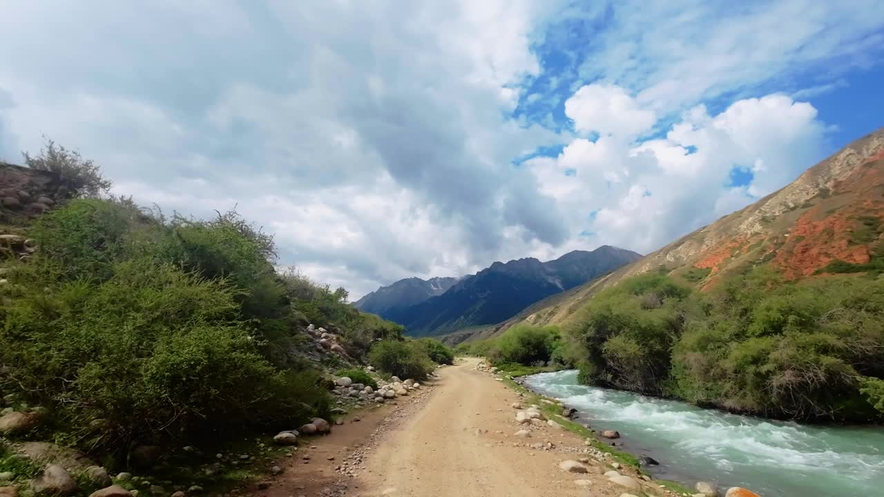 在云层下的夏日峡谷的红色岩石形成的河岸上移动视频素材