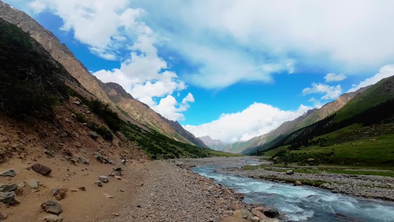 多云的天空下，夏日峡谷里沿着山河岸的岩石小径视频素材