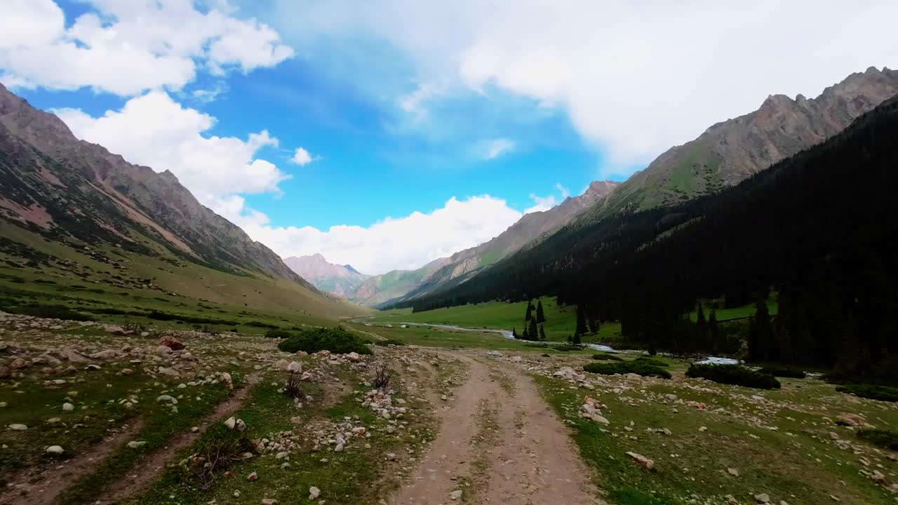 在多云的夏日峡谷中，沿着风景秀丽的山畔旅行视频素材