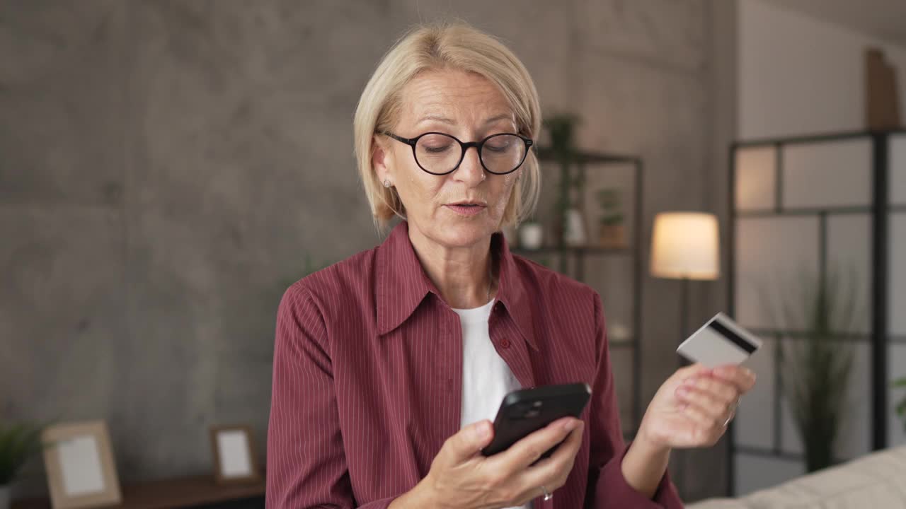 成熟的女人在网上购物，在家用信用卡和手机视频素材