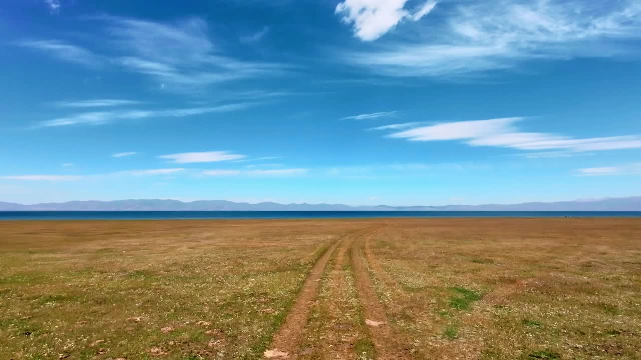 沿着草地上的轮胎痕迹向高地湖移动视频素材