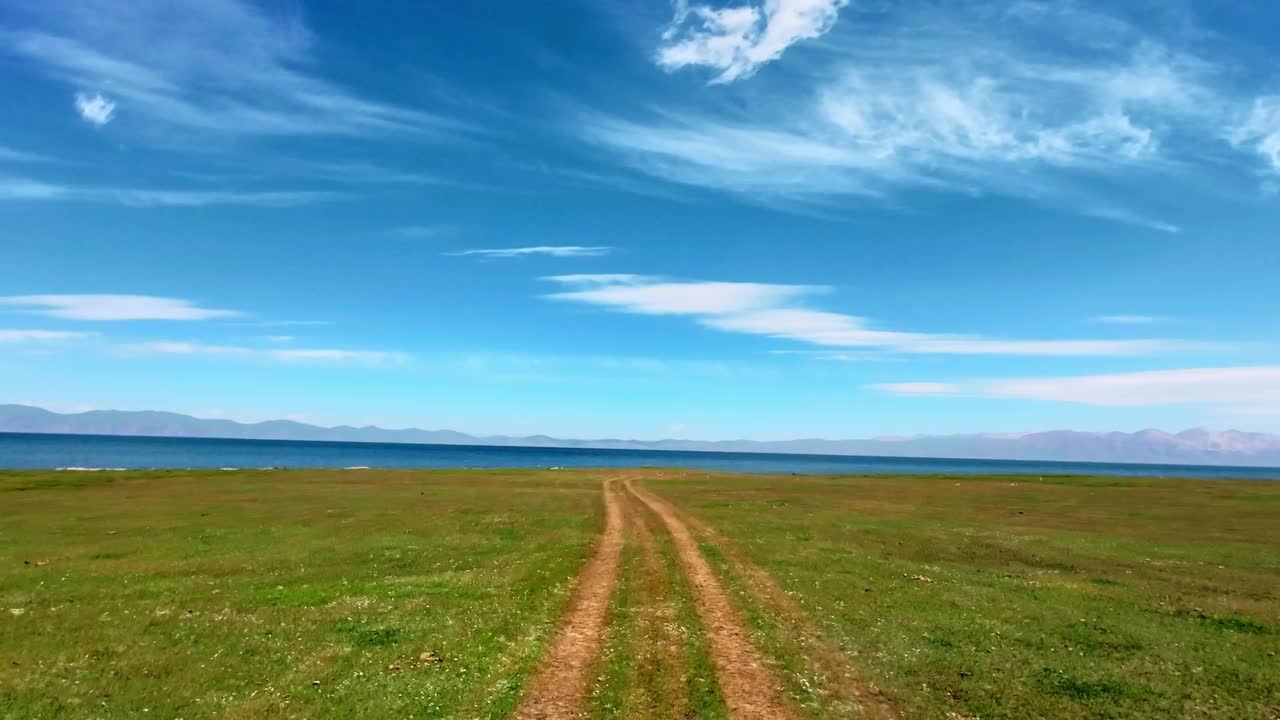 沿着草地上的轮胎轨迹行驶到高地湖视频素材