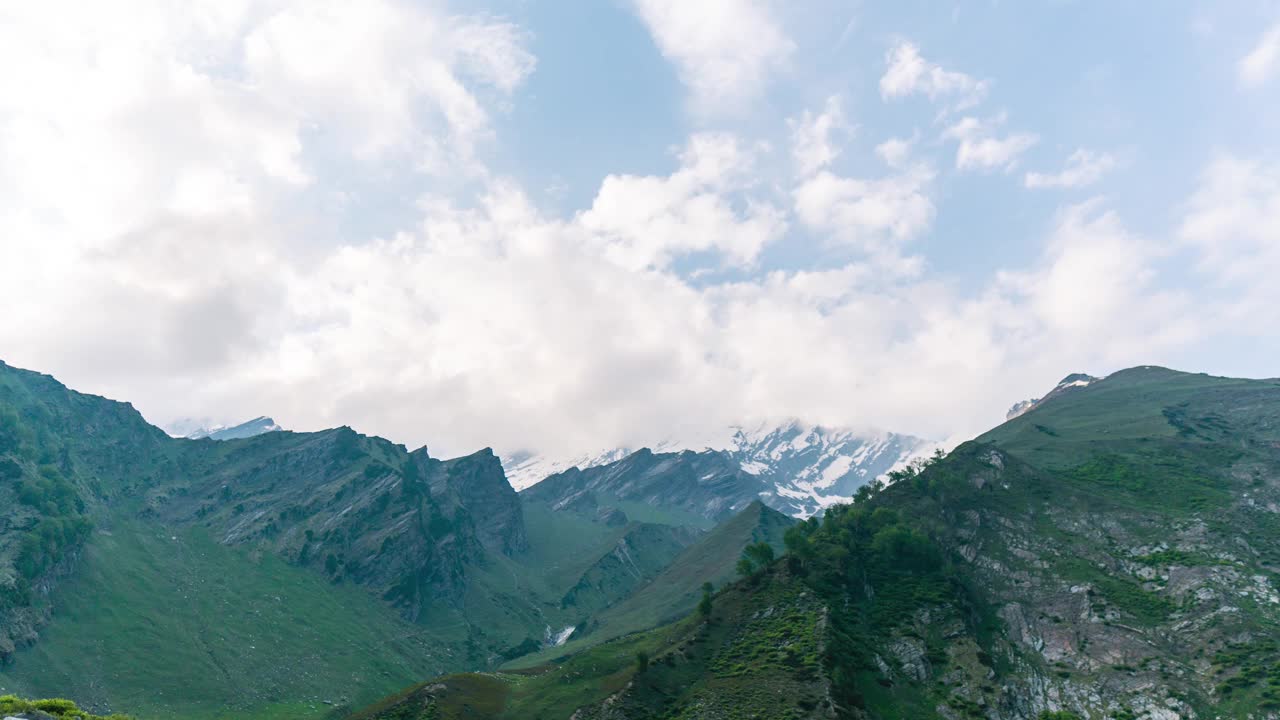 4K延时云和山。夏日之美，有碧绿的草地和白雪皑皑的山峰。有旅游和度假背景。视频素材